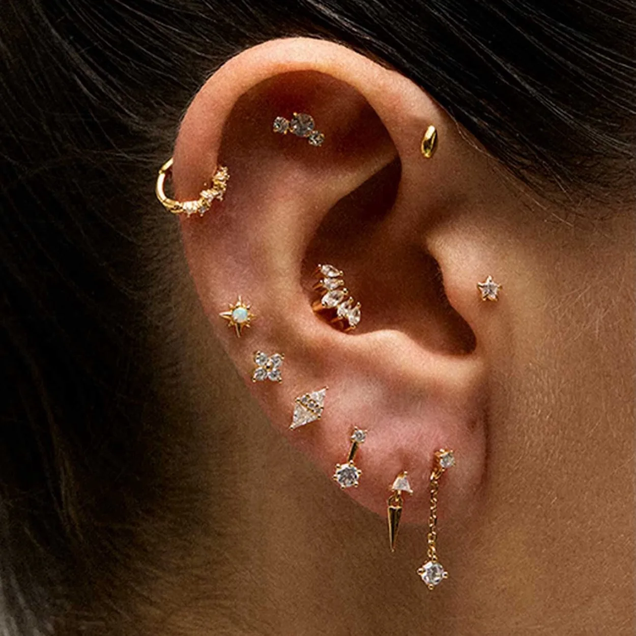 Composicion de piercings y pendientes de oro de Adamina