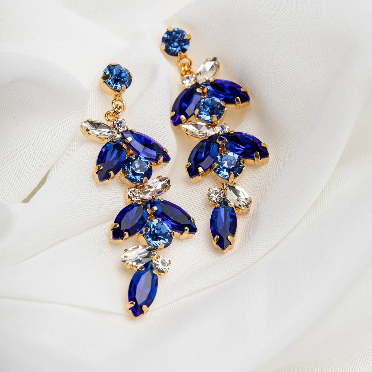 Pendientes de cristal azul sobre seda blanca de Piedra de Toque