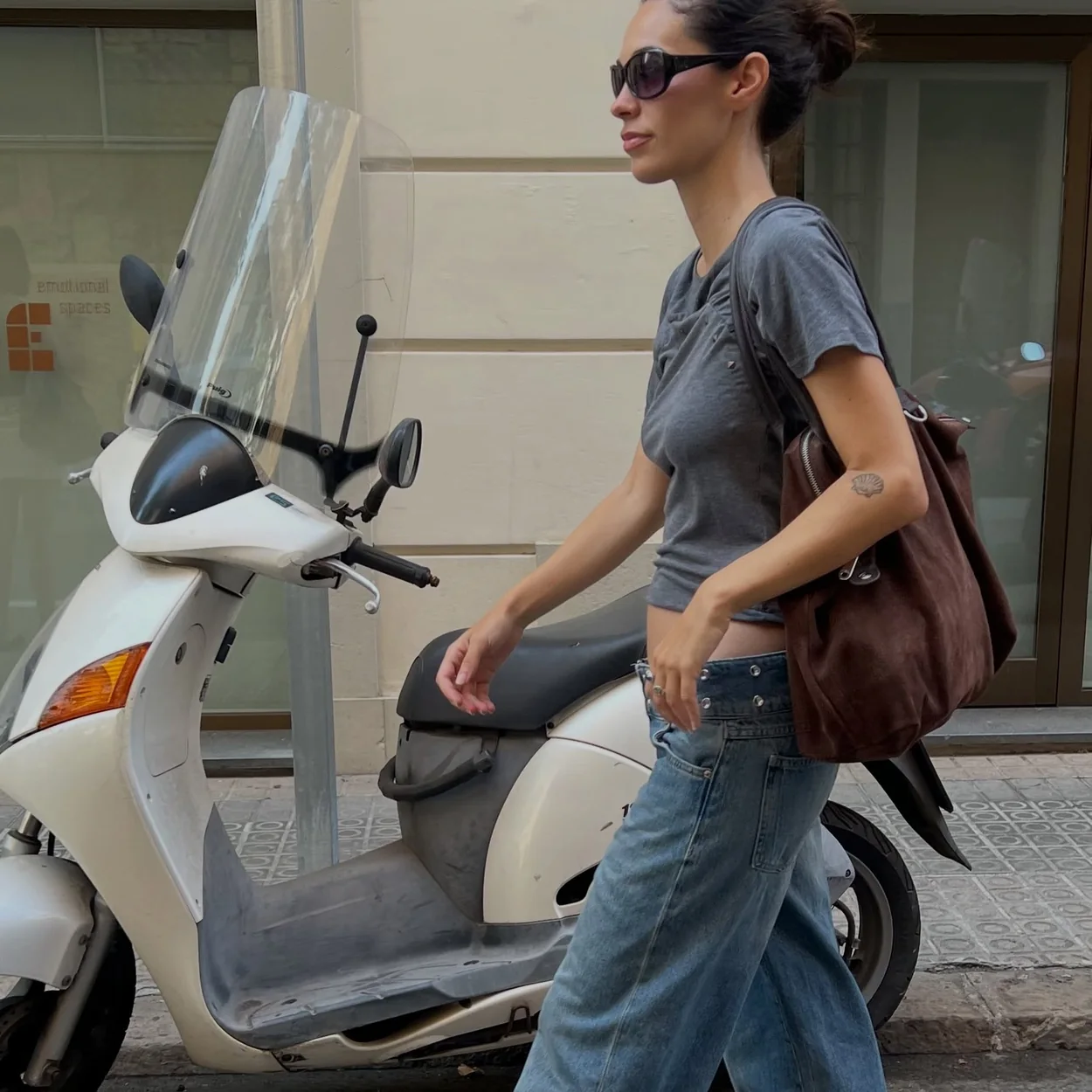Modelo con camiseta gris y bolso marron de Brownie en la calle