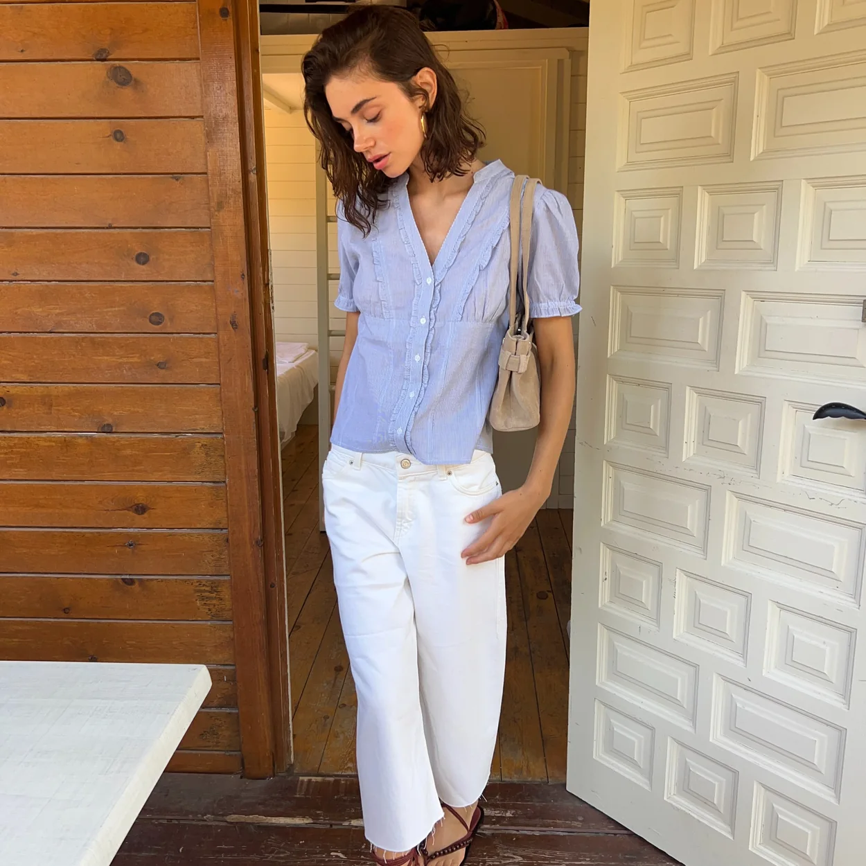 Modelo con blusa azul y vaqueros blancos de Brownie