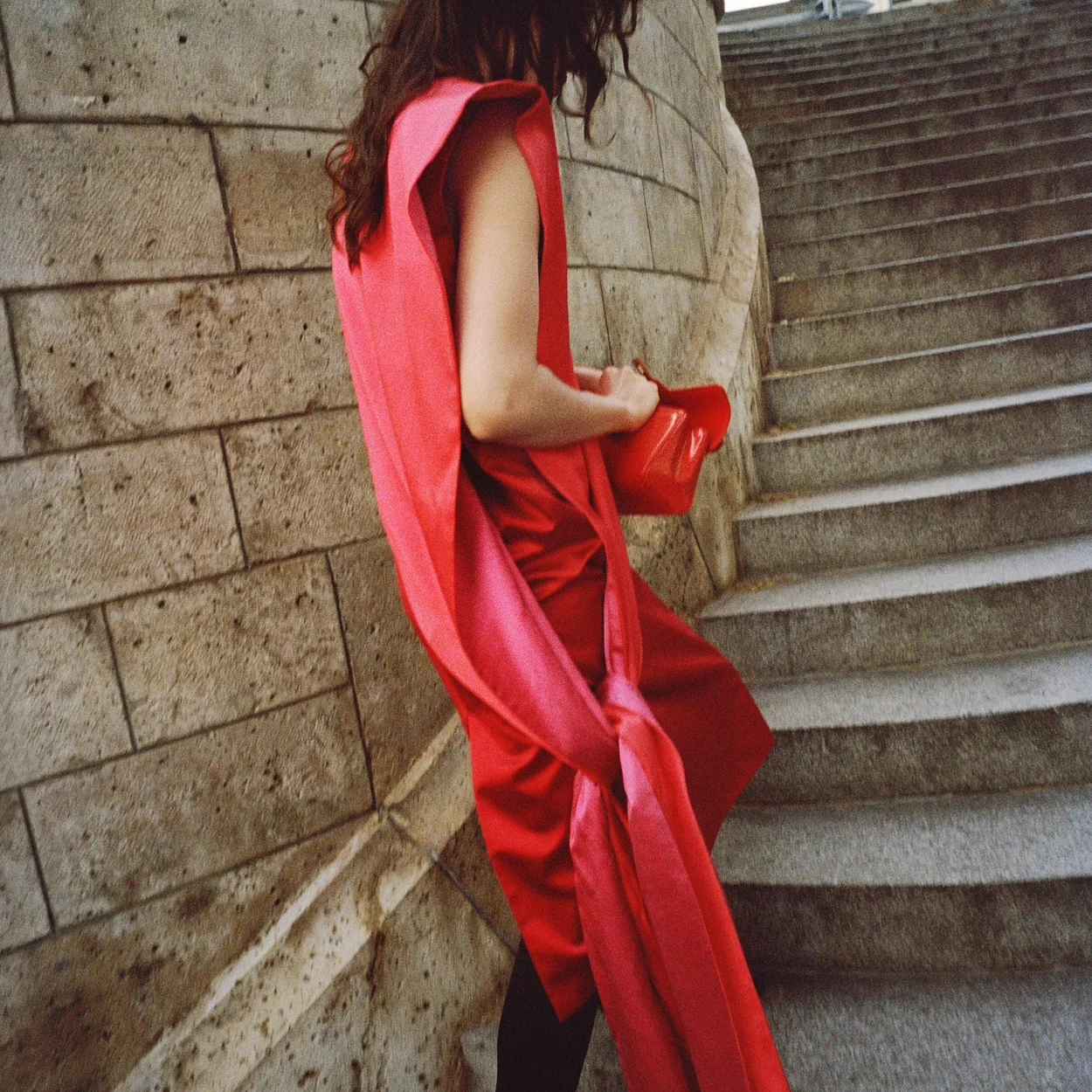 Modelo con vestido rojo de Celine en unas escaleras