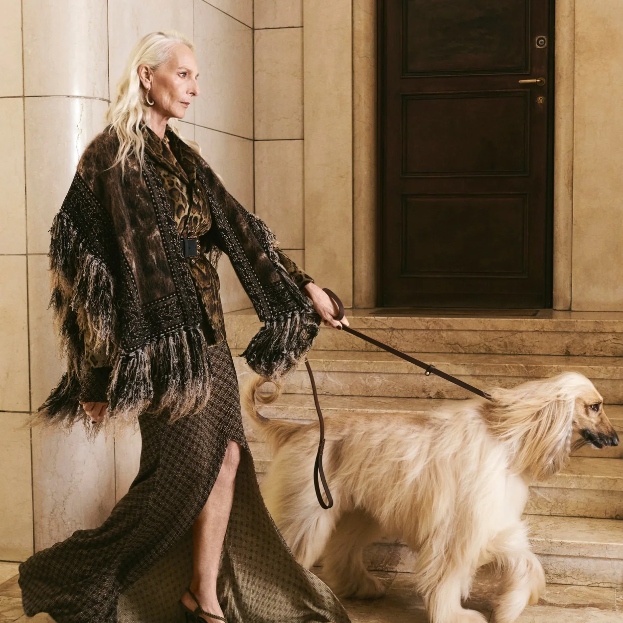 Modelo con vestido de flecos de Etro paseando un perro