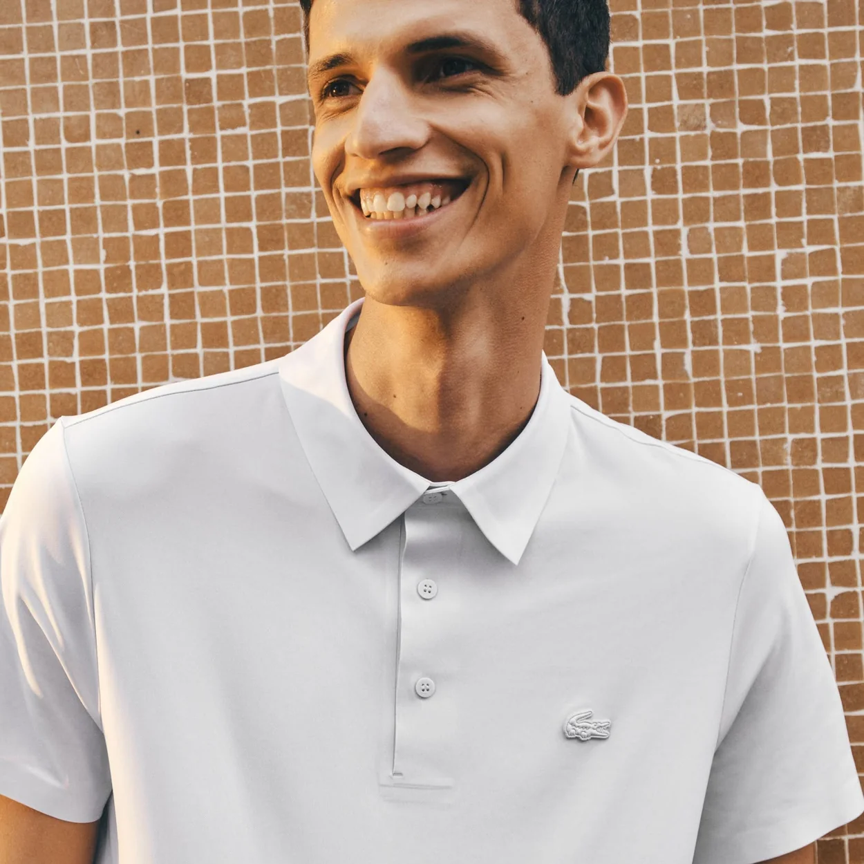 Hombre con polo blanco de pique de Lacoste