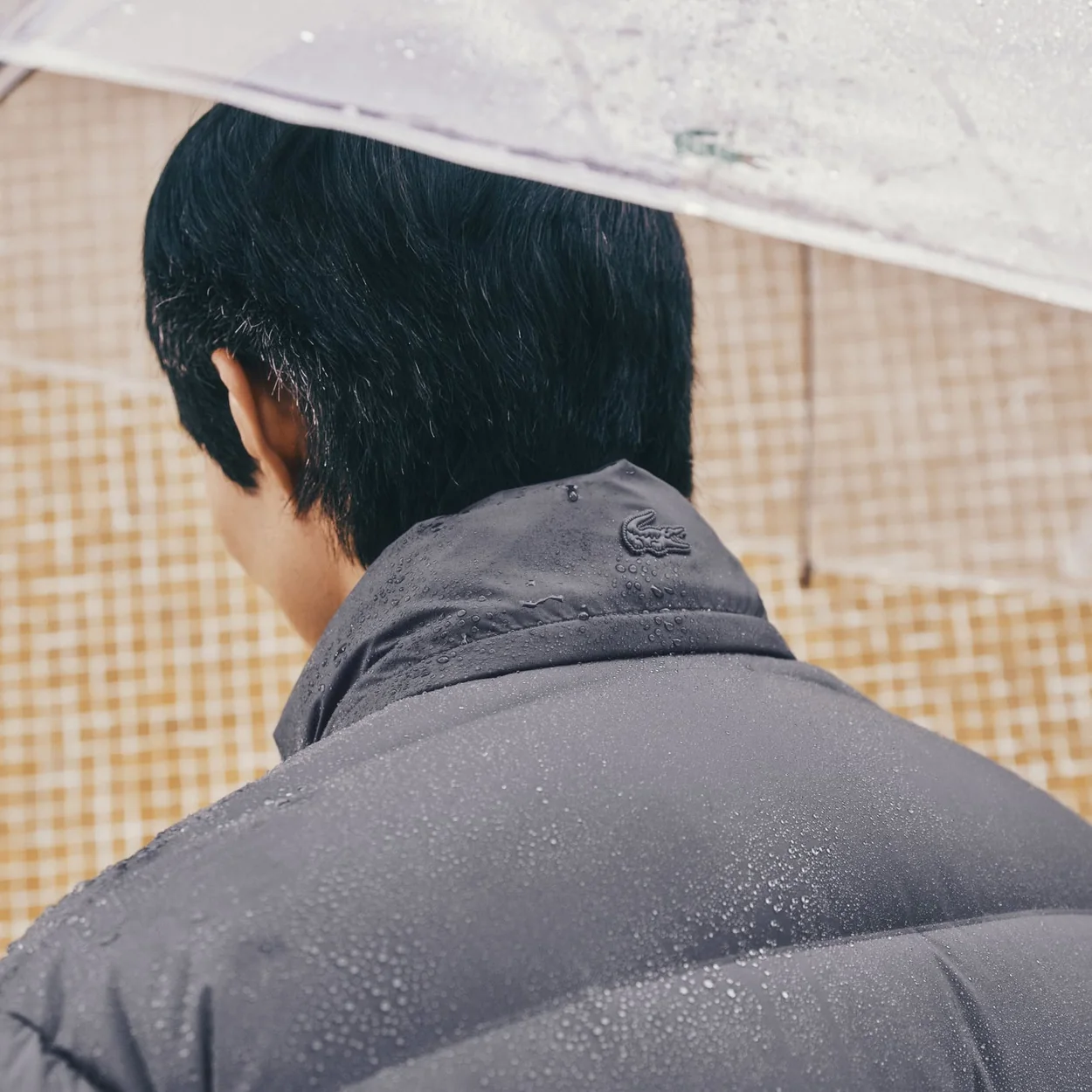 Chaqueta impermeable gris de Lacoste bajo la lluvia