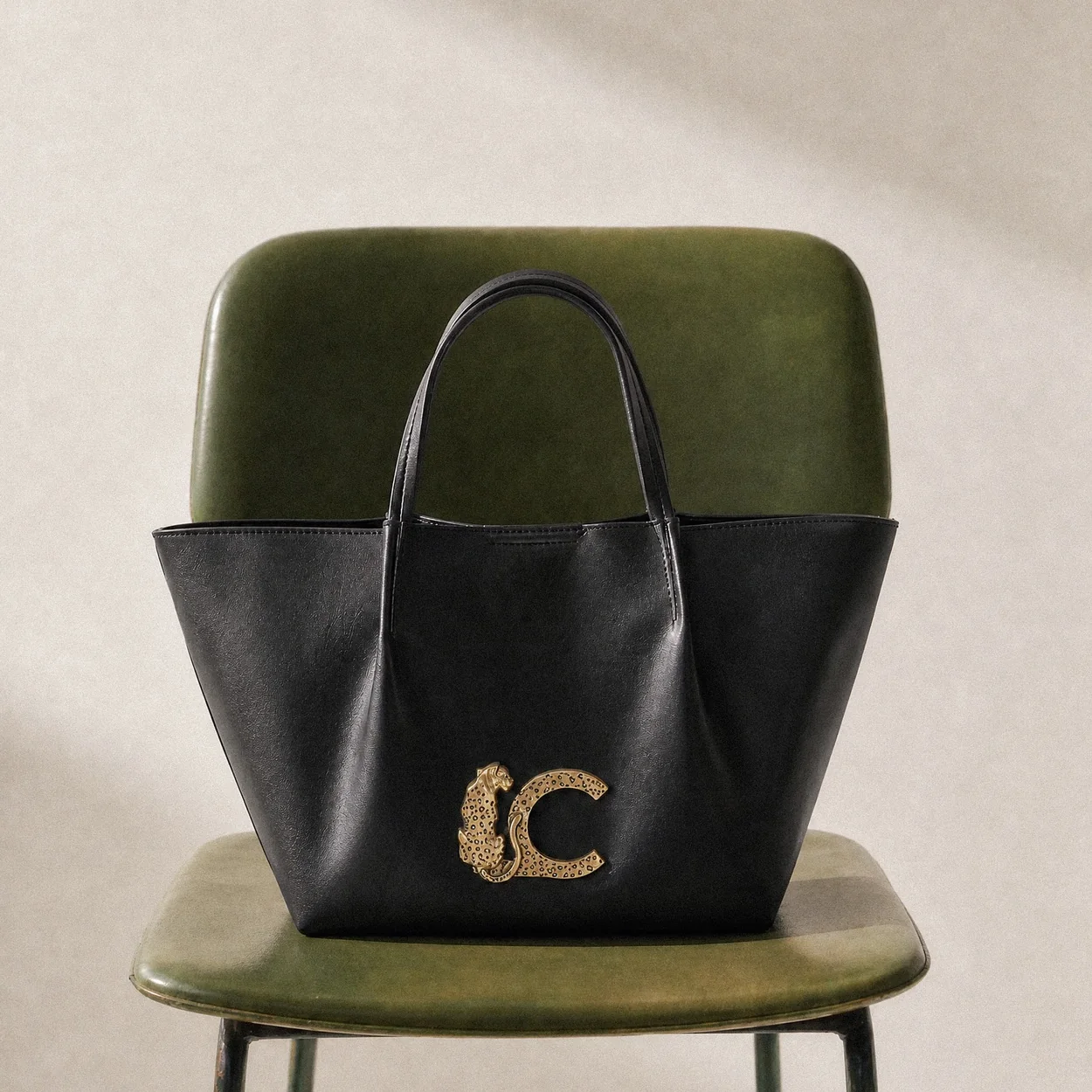 Bolso tote verde y negro de Lola Casademunt sobre una silla