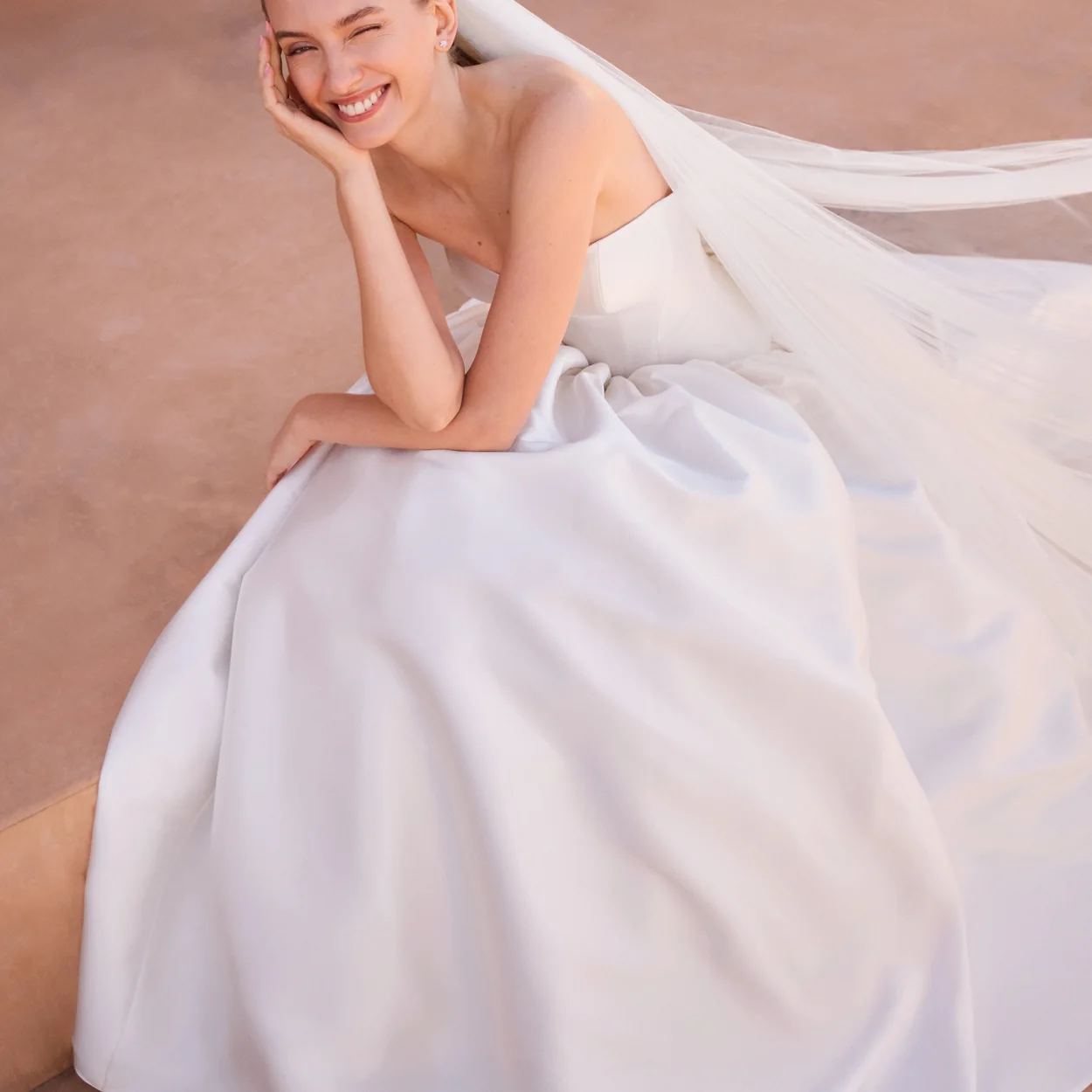 Vestido de novia de raso con lazo y velo de Pronovias