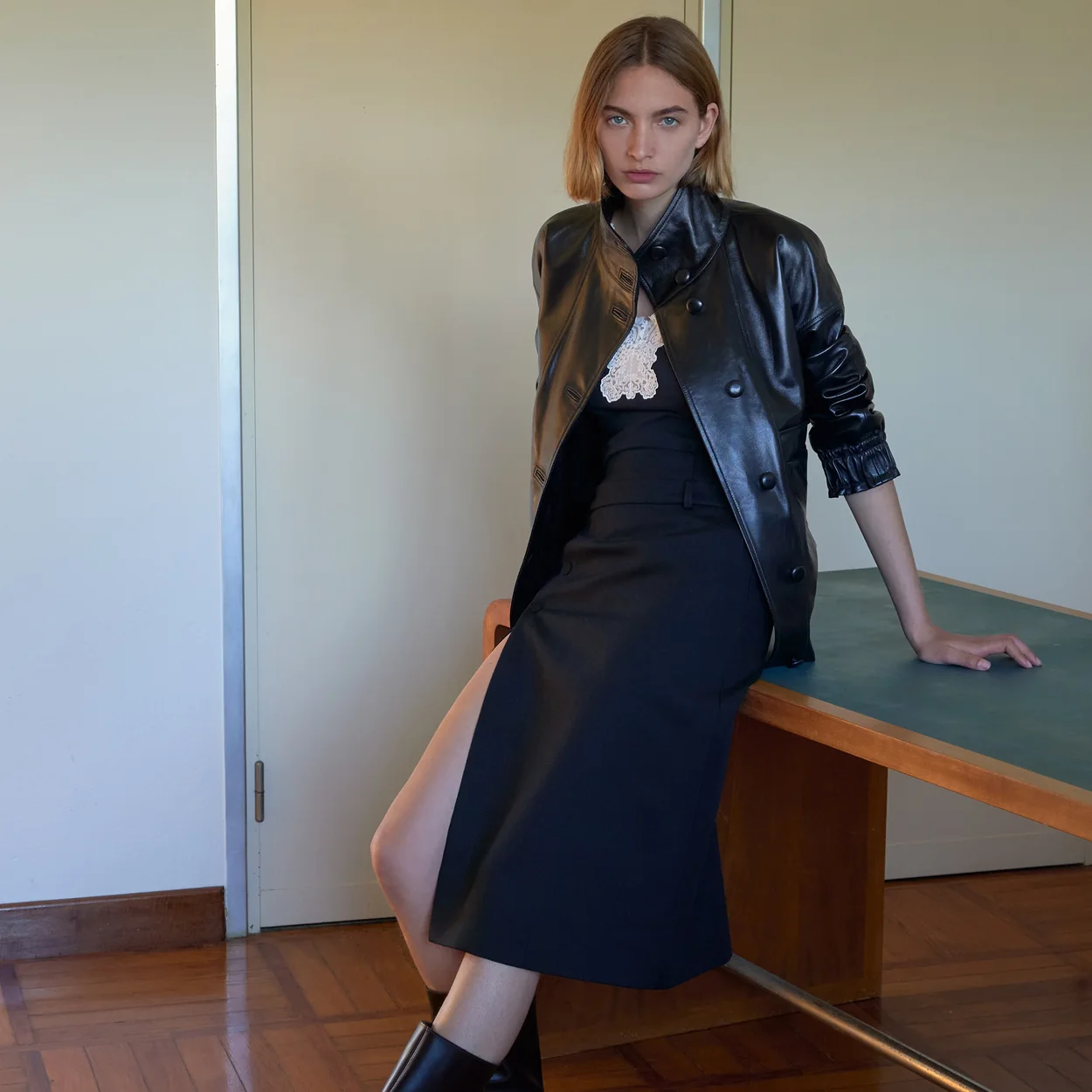 Modelo con cazadora de piel y falda midi de Sandro