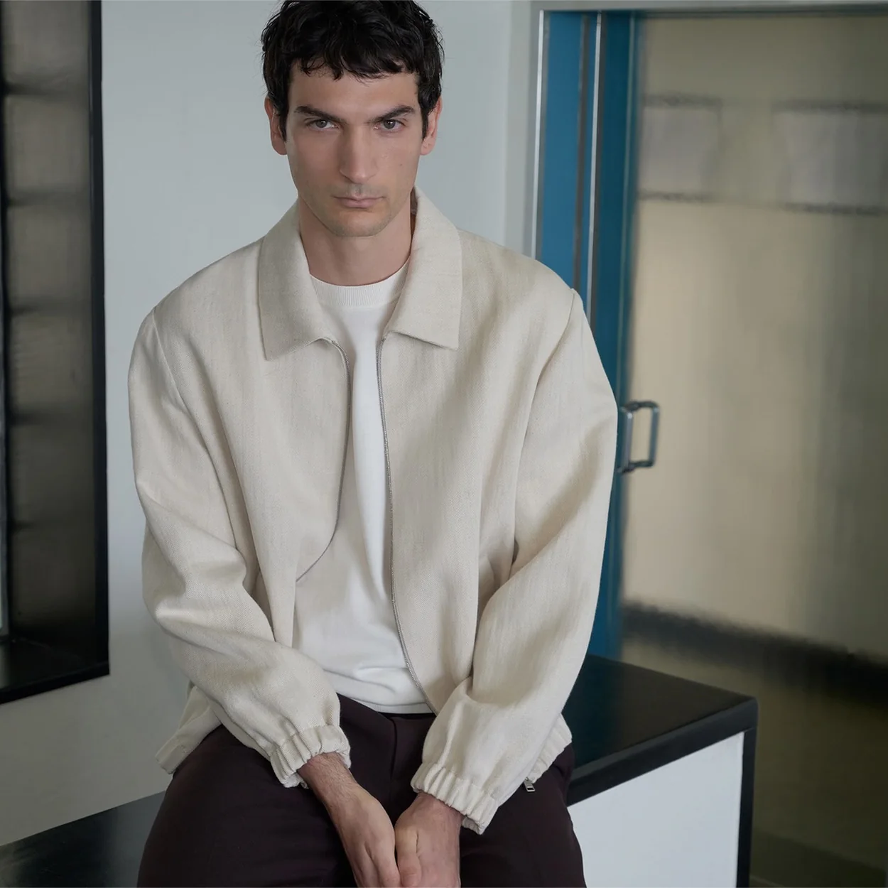 Hombre con bomber crudo y pantalon marron de Sandro