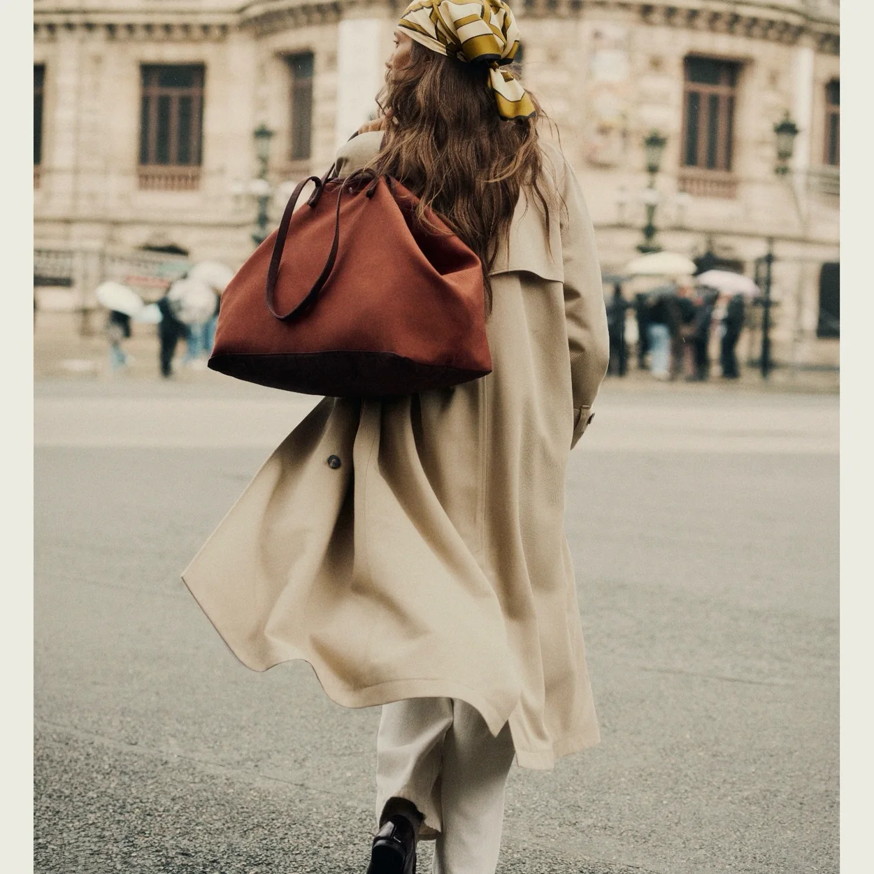 Modelo con gabardina y bolso granate de Sezane en la calle