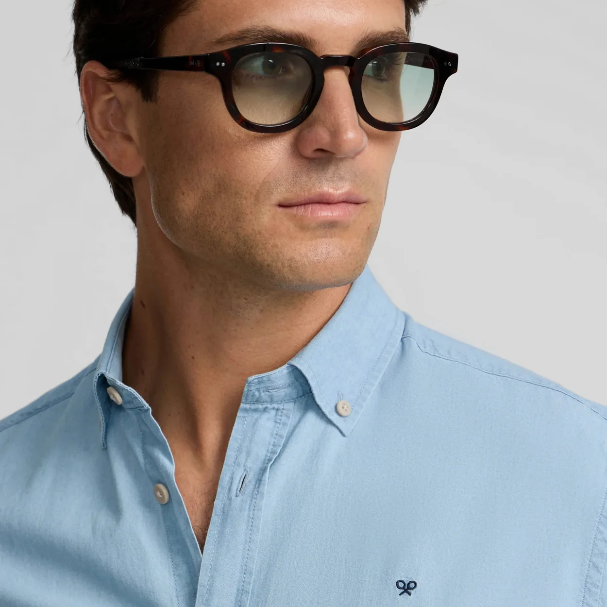 Hombre con camisa azul claro y gafas de Silbon