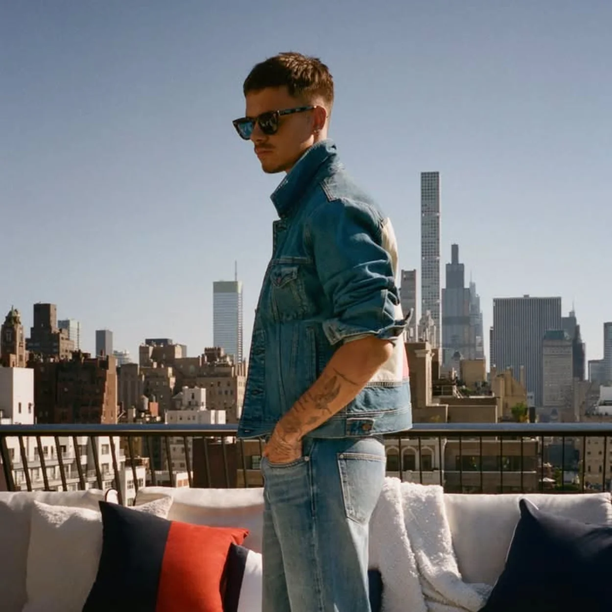 Hombre con conjunto vaquero de Tommy Hilfiger en una terraza