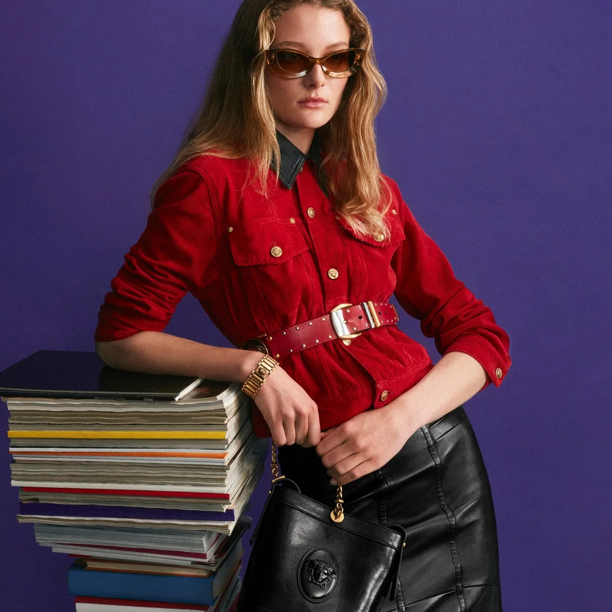 Modelo con camisa roja y pantalon de piel de Versace