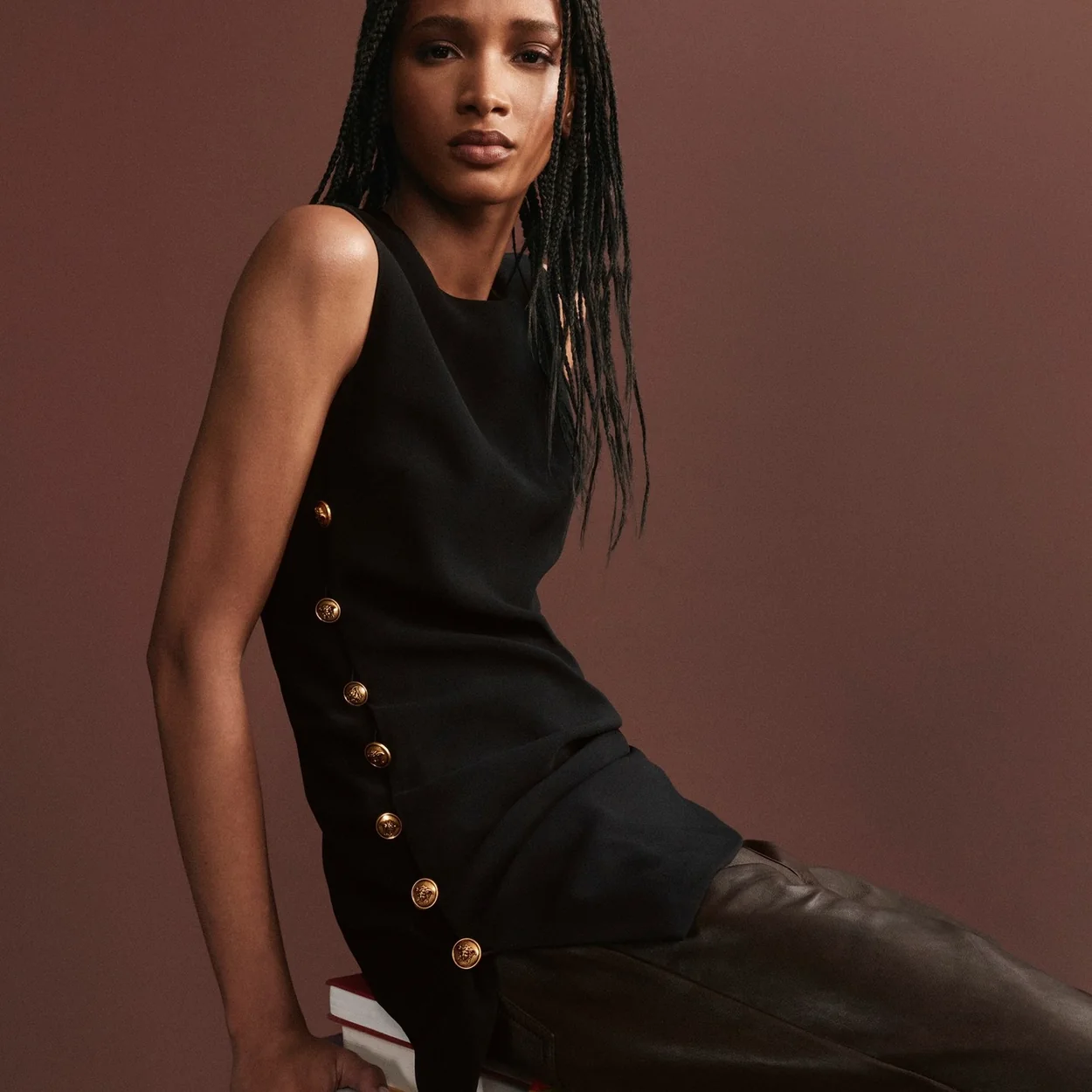 Modelo con vestido marron de botones dorados de Versace