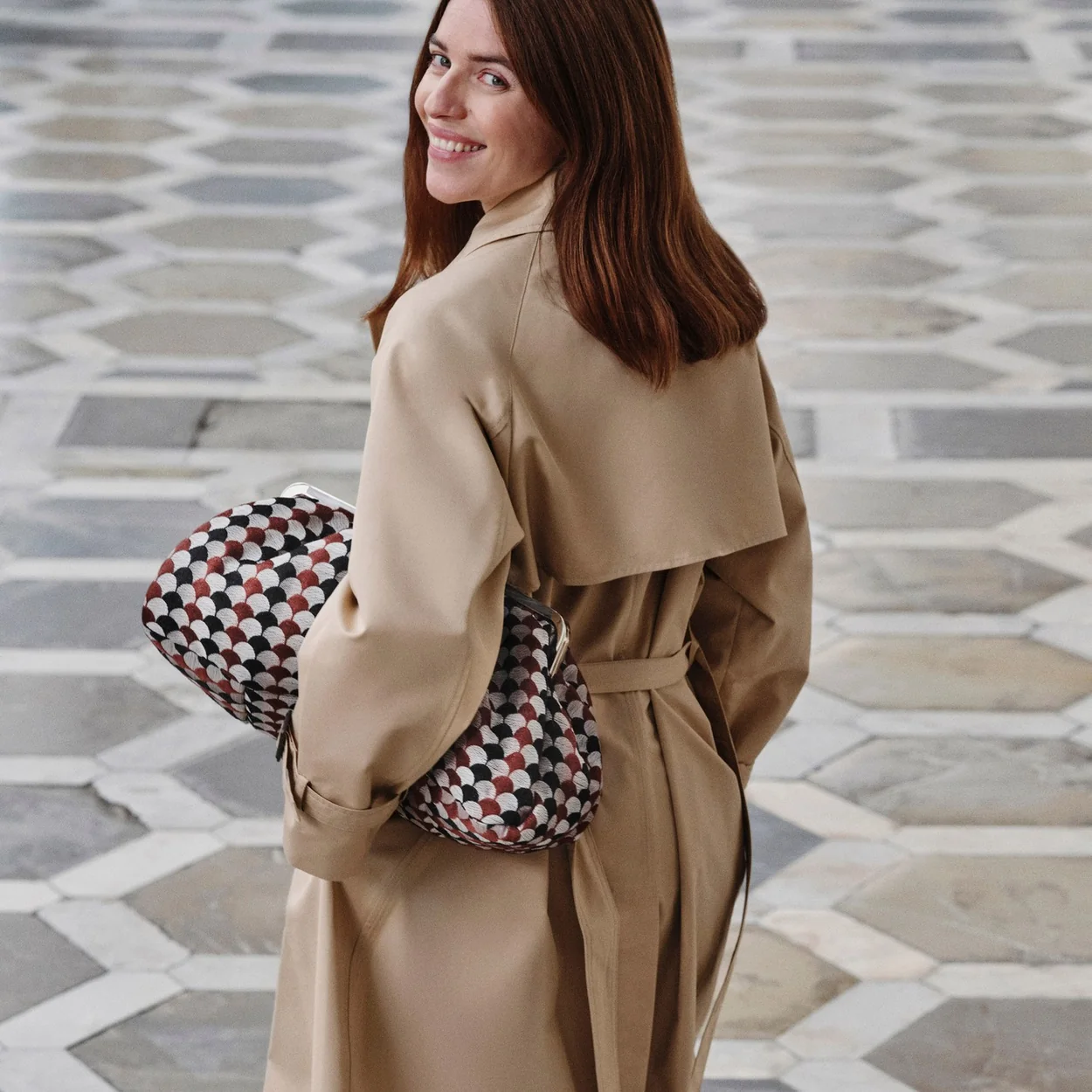 Modelo con gabardina camel y bolso de cuadros de Weekend Max Mara