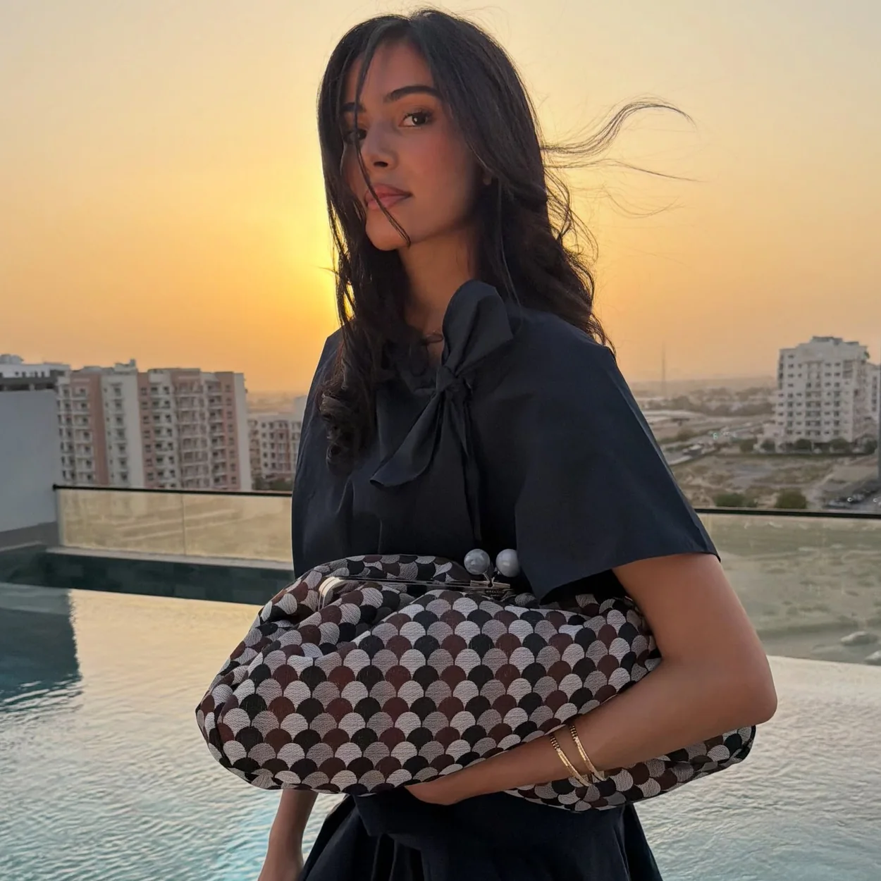Modelo con bolso de cuadros de Weekend Max Mara al atardecer