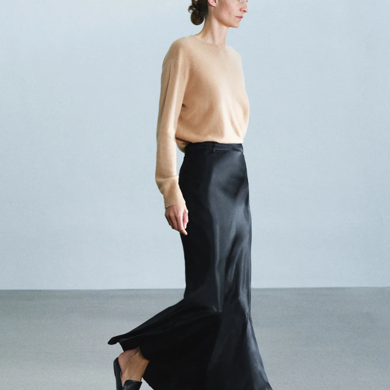 Modelo con top beige y falda larga negra de Zara
